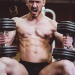 man holding two dumbbells
